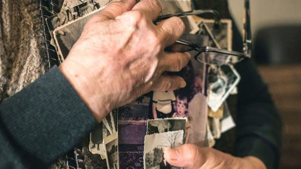 A self-portrait of a woman's hands holding old family photographs