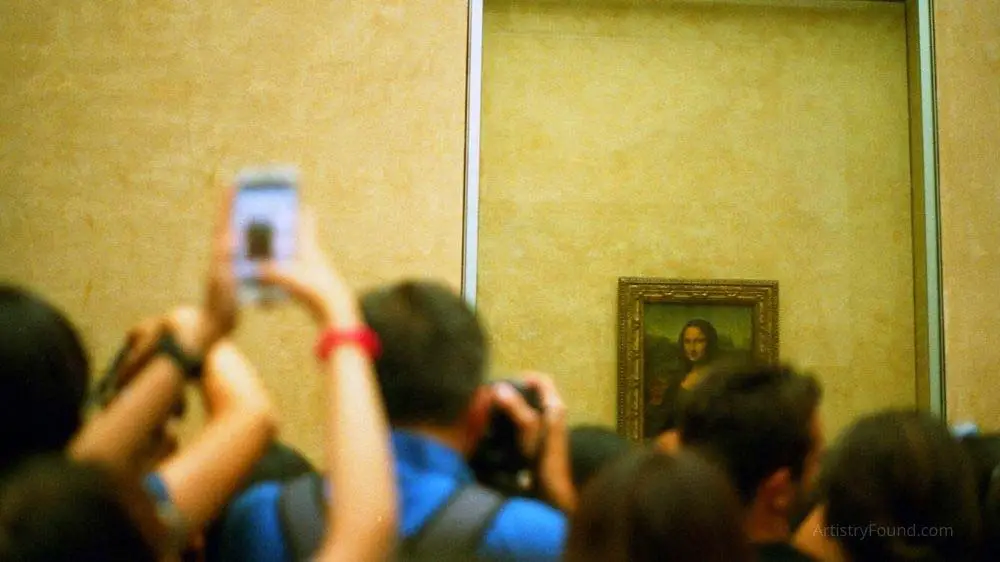 A crowd of camera phone carrying enthusiasts visiting the Mona Lisa.