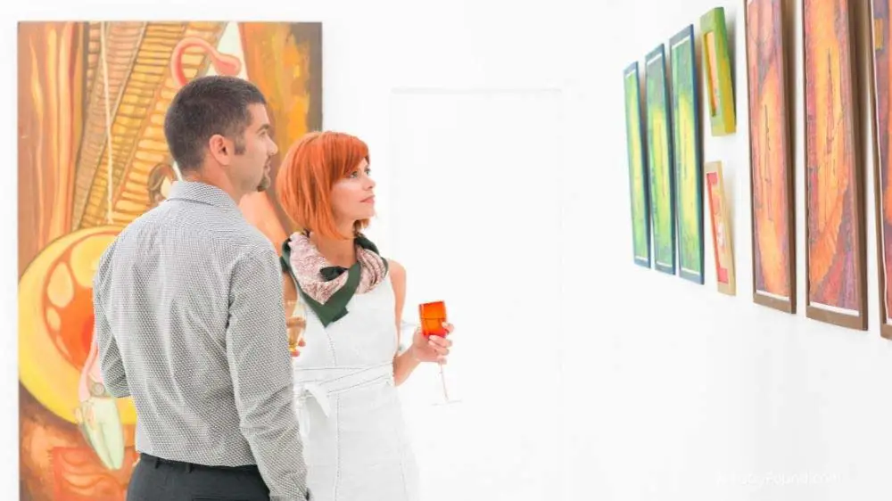 A couple examining an art piece before purchase.